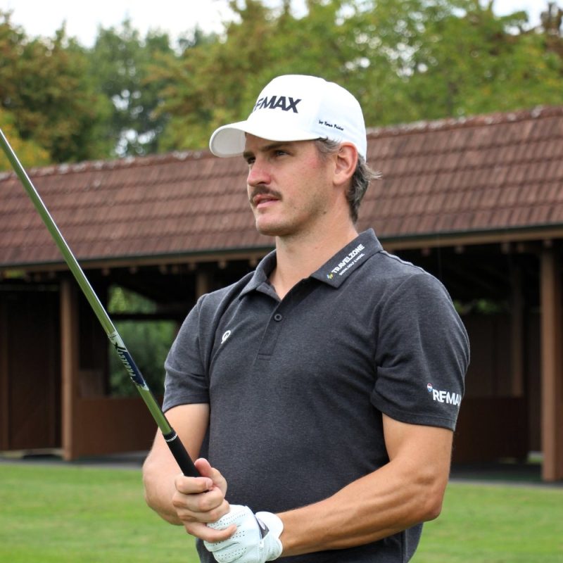 Zeno Felder auf der Driving Range mit REMAX Cap und Travelzone Polo